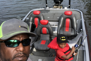 Toddler boy in bass boat fishing with dad