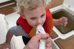 Toddler kissing a fish