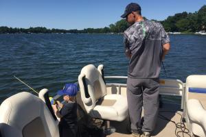 Young child & father fishing form pontoon