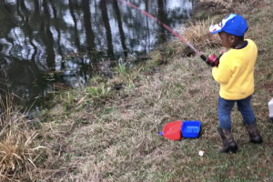 Serious young angler fishing in a pond