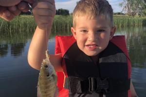 Young boy posing with his small bluegill