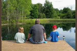 Father, son & daughter fishing from a dock