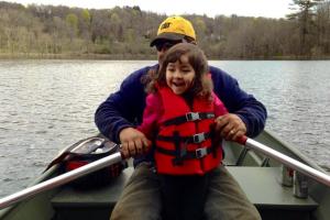 Young girl helping dad row the boat