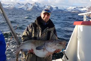 Angler in northern sea with a large fish