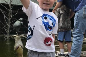 Young Jax holding up a fish at Bass Pro's kids fishing day