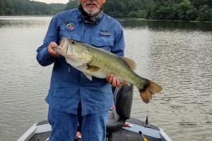 Angler standing in a boat hold a big bass