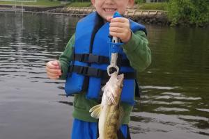 Young boy holding a walleye fish he caught
