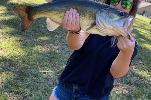 Lady bass angler holding a largemouth bass