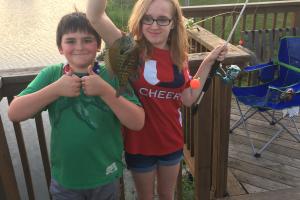 Two young anglers a boy and girl hold up a bluegill