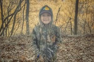 Young boy in camo jacket in the outdoors