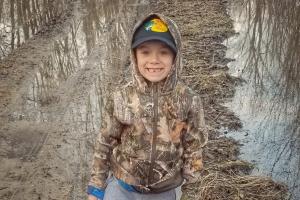 Young boy hiking in a flooded area