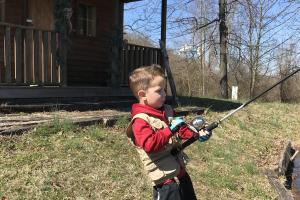 Young boy fishing from the bank of a lake