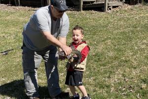 Young boy given a fish to hold