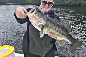 Lady angler holding up her big bass catch