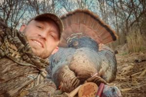 Turkey hunter with his gear and his turkey