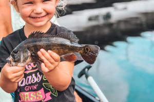 Young girl holding up her fish