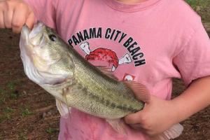 Boy angler holding bass