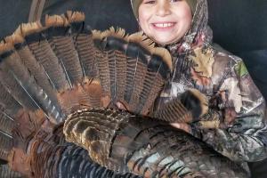 Boy turkey hunting with large gobbler