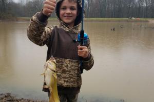 Boy angler holding up catfish