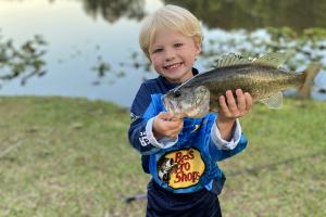 Young boy near pand with bass