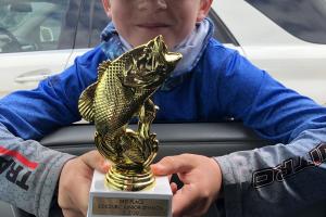 Young boy with hisfishing tournament trophy