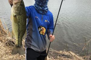 Boy angler holding bass