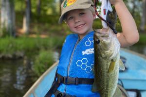 Boy in boat holding bass