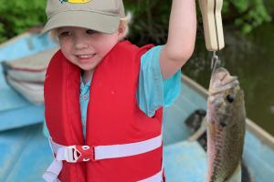 Small boy angler weighing a bass