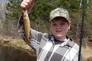 Young trout angler holding up a trout
