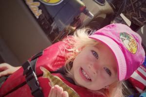 Young girl holding small fish