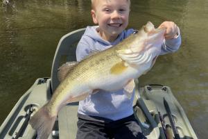 Proud young angler holding bass