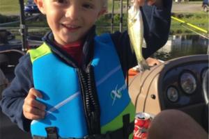 Young boy holding his 1st bass