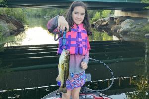 Young girl holding a river bass