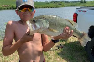 Young angler holding big bass