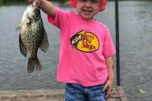 Little girl holding up fish
