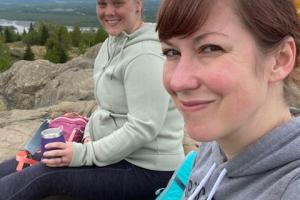 2 people sitting on a rock ridge