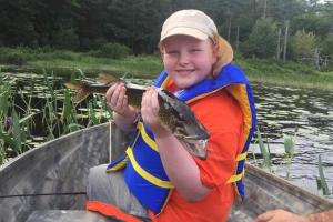 Young angler in boat with fish