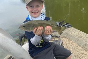 Boy with bass pro hat holding fish